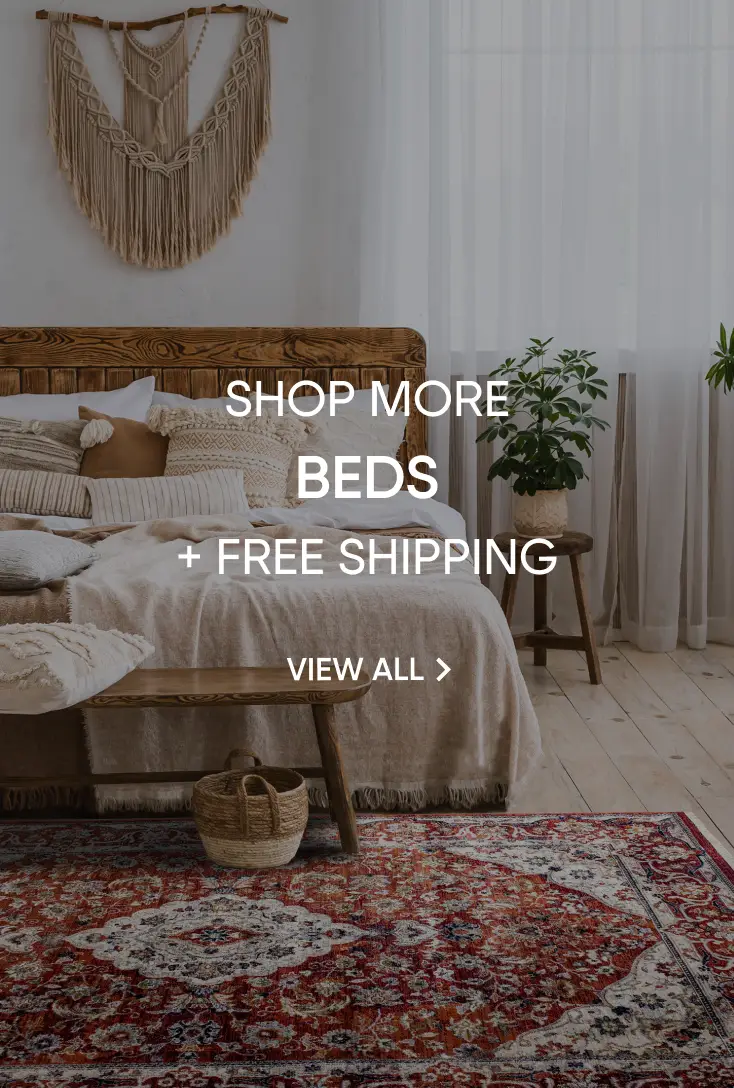 SHOP MORE BEDS + FREE SHIPPING. A cozy bedroom with a wooden bed frame, textured bedding, and a patterned rug.
