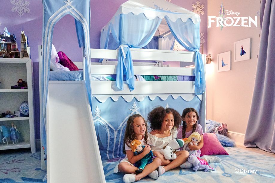 Disney Frozen themed bedroom with a bunk bed, slide, and three girls holding dolls.
