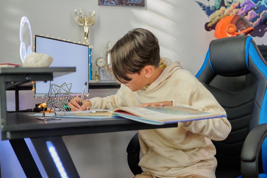 A person writing in a book at a desk.
