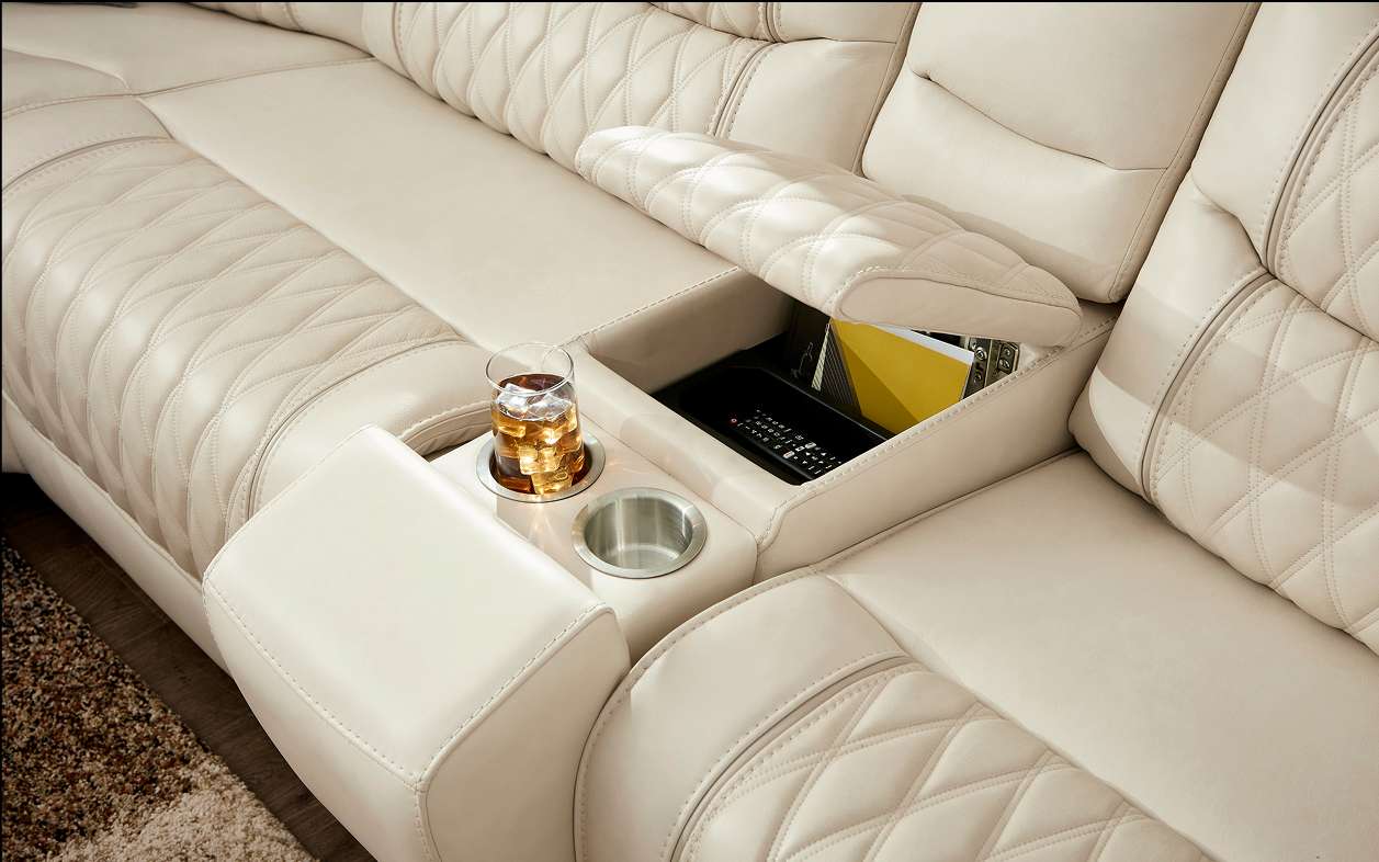 Cream-colored leather sectional sofa with a built-in cup holder and storage compartment.
