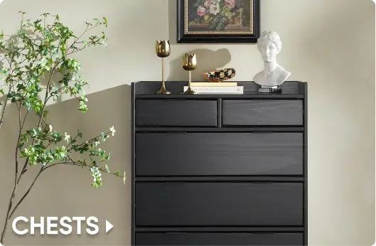 CHESTS. A modern black wooden dresser with five drawers, decorated with gold tulip-shaped candle holders and a bust.