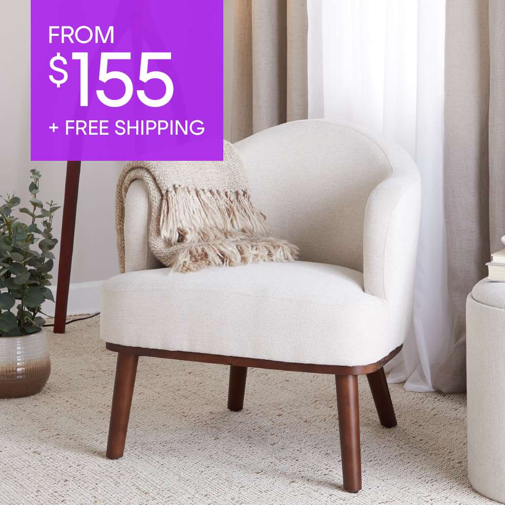 FROM $155 + FREE SHIPPING. A cream-colored armchair with a blanket on it.
