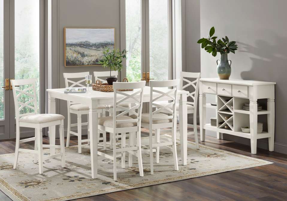 White dining set with a table, chairs, and a sideboard on a patterned rug.

