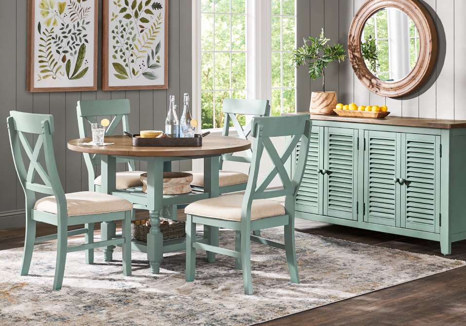 A dining room set with a round table, chairs, and a sideboard.
