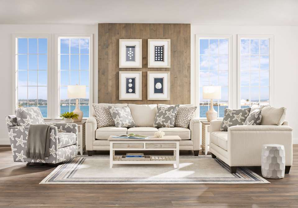 Living room with a sofa, two armchairs, a coffee table, and framed artwork.
