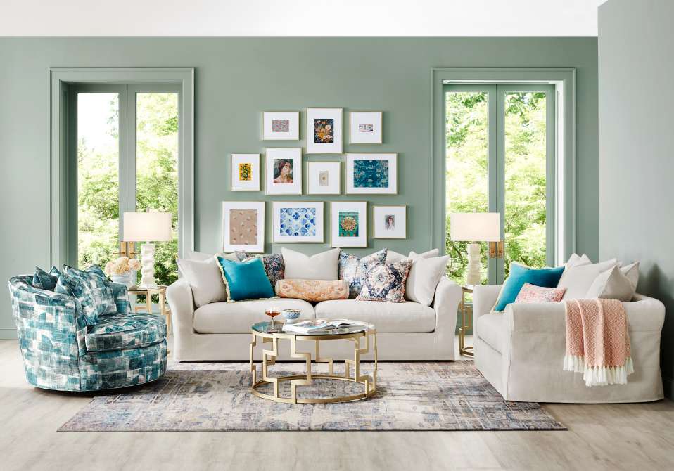 Living room with a white sofa, patterned chair, and gold coffee table.
