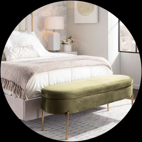 Olive green velvet bench with gold legs in a bedroom.
