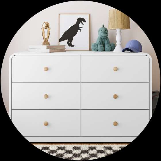 White dresser with wooden knobs, a dinosaur print, and a lamp.
