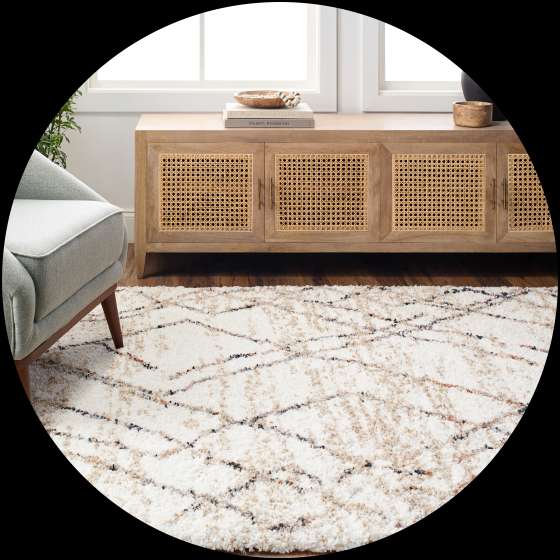 Cream-colored geometric patterned rug in a living room setting.
