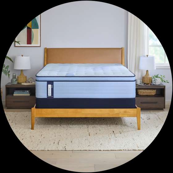 A bed with a light blue mattress and a wooden frame.
