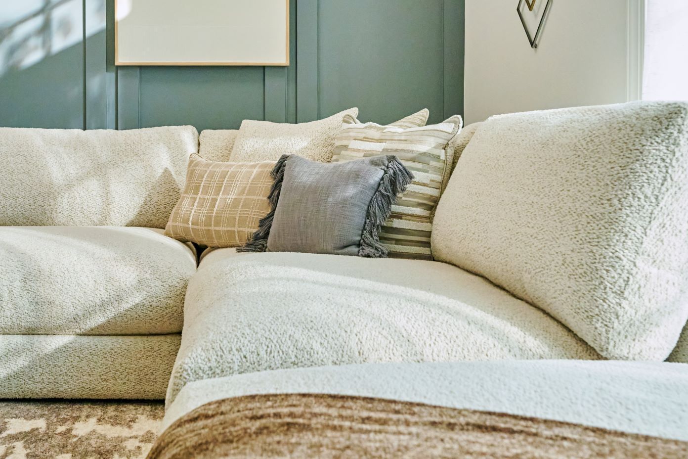 Cream-colored sectional sofa with decorative pillows.
