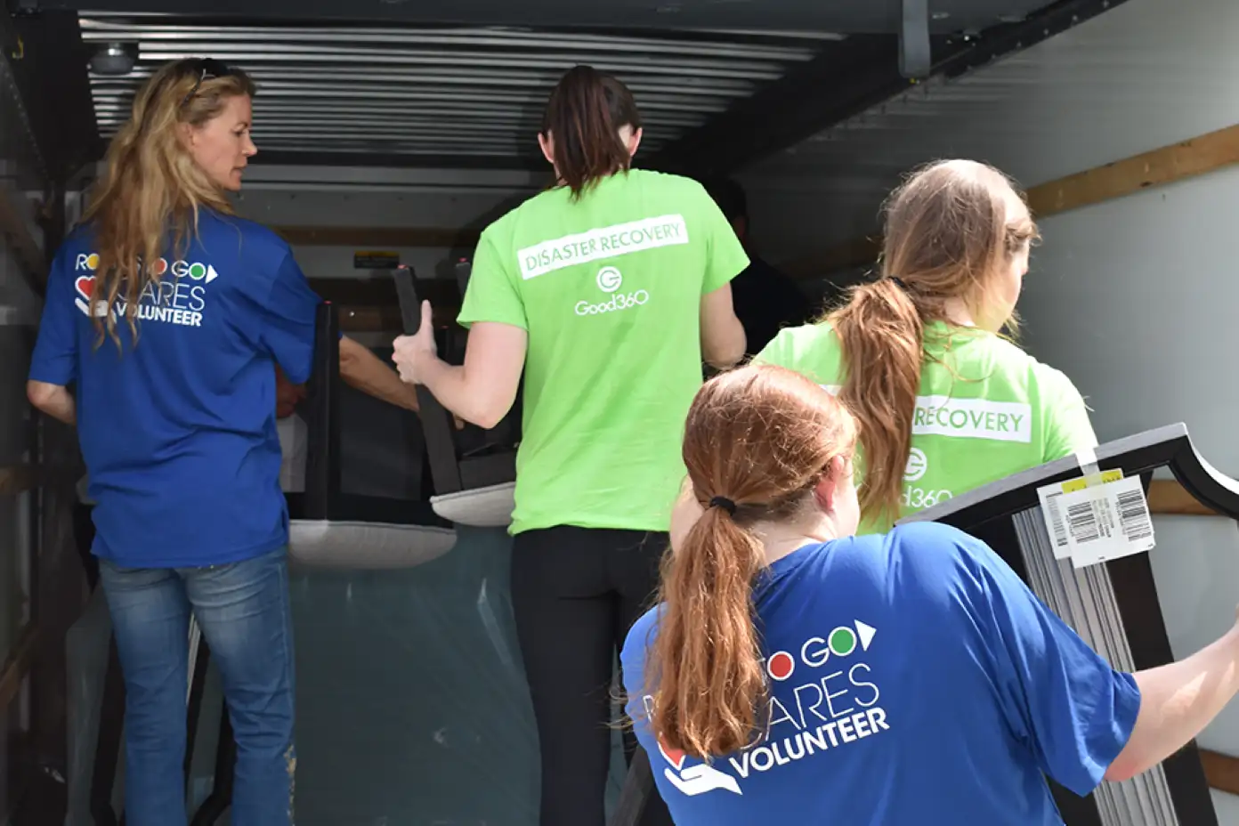 Volunteers loading furniture into a truck.
