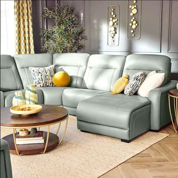A gray sectional sofa with pillows in a living room.
