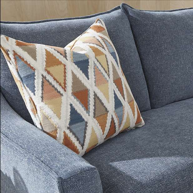 Blue sofa with a patterned pillow.
