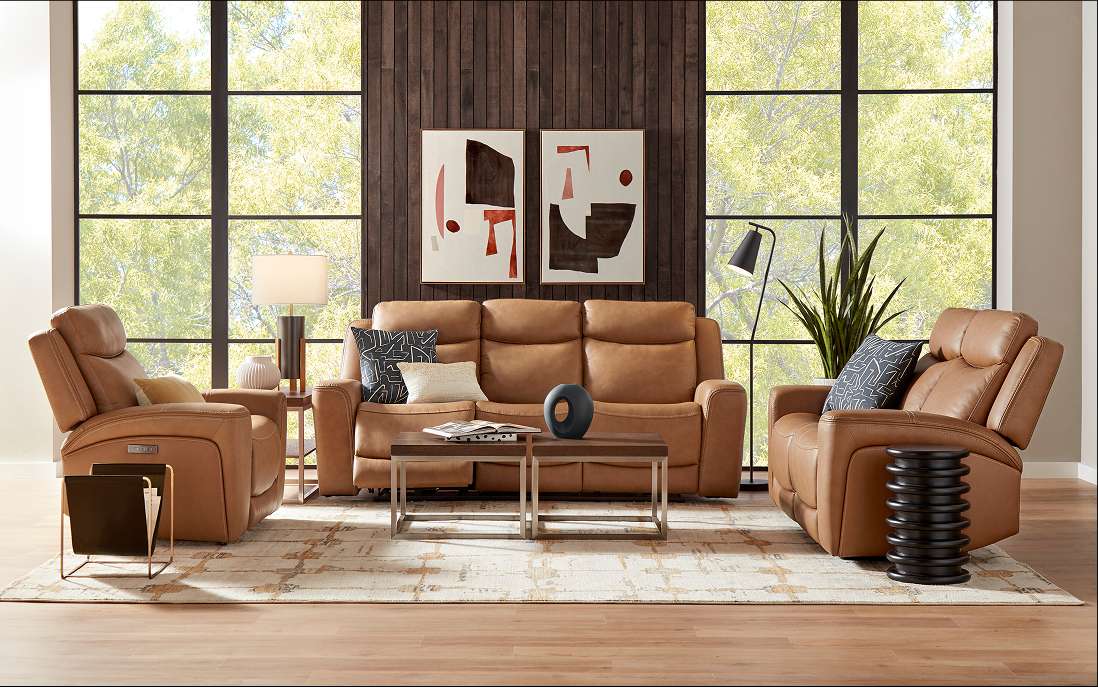 Living room with brown leather furniture, two abstract paintings, and a large window.

