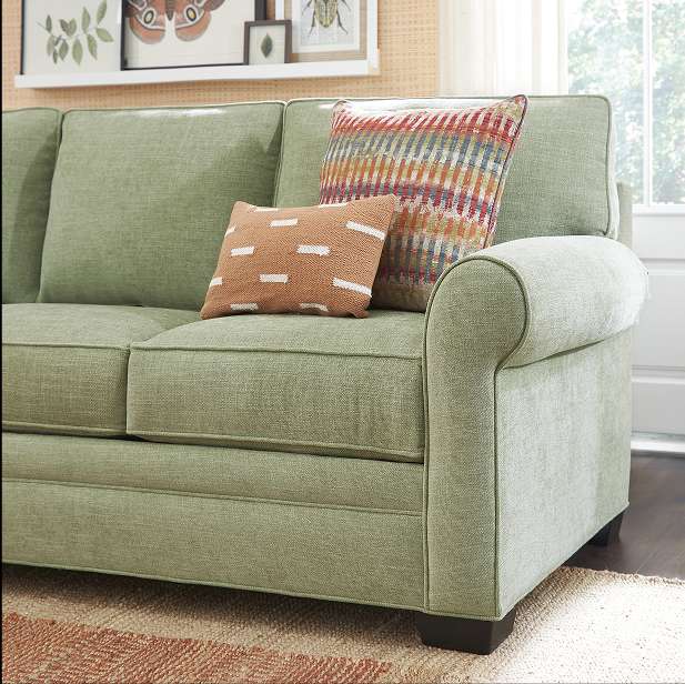 Green sofa with decorative pillows.
