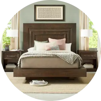 Dark wood bed with matching nightstands, lamps, and artwork.
