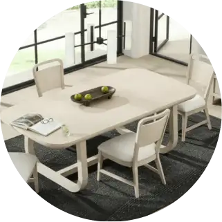 Dining table and chairs set on a dark rug.
