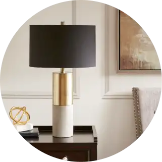 Table lamp with a black shade and gold and concrete base.
