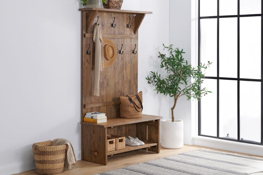 Wooden entryway bench with hooks, shelf, and storage. A scarf, hat, and bag hang on the hooks.
