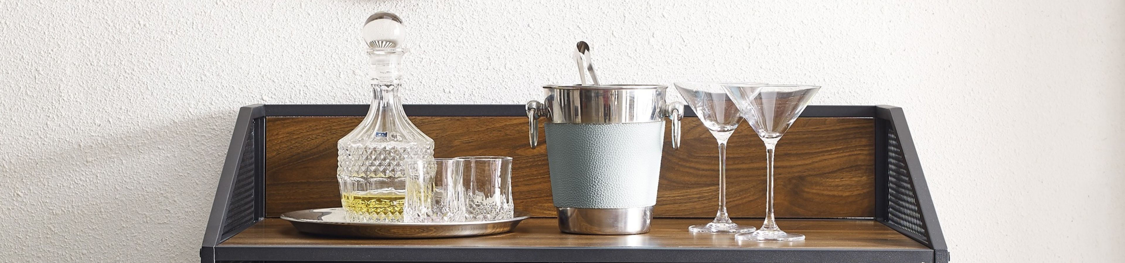 Bar cart with decanter, glasses, ice bucket, and martini glasses.
