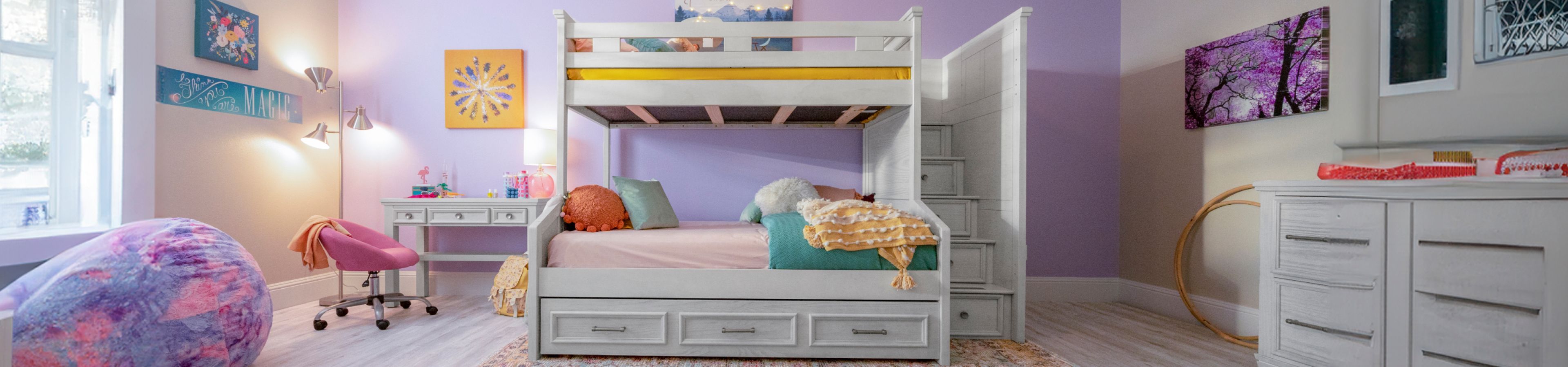 A bedroom with a bunk bed, desk, and beanbag chair.
