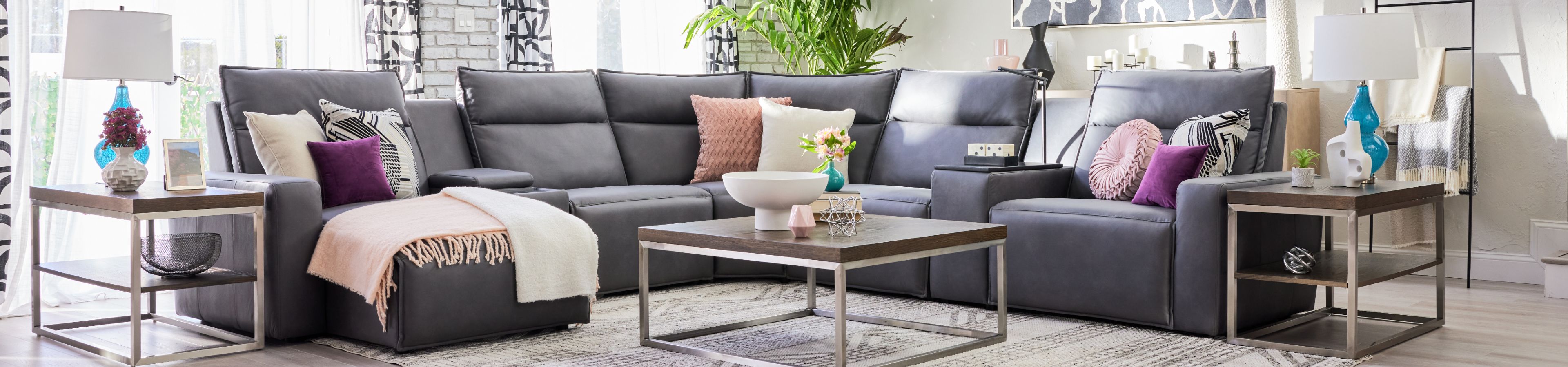 Gray sectional sofa with pillows and a coffee table.
