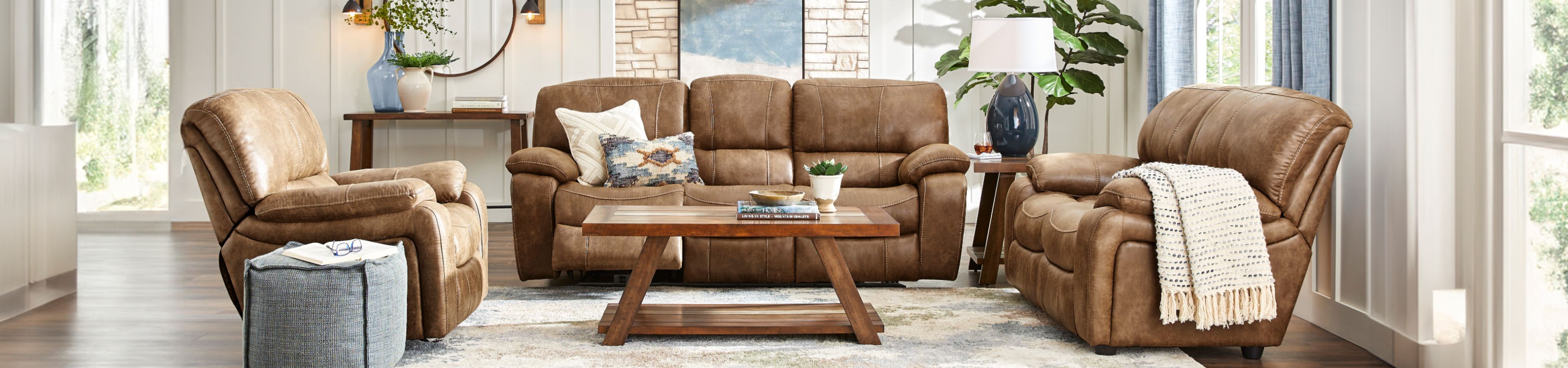 Living room with brown leather furniture, a coffee table, and a rug.
