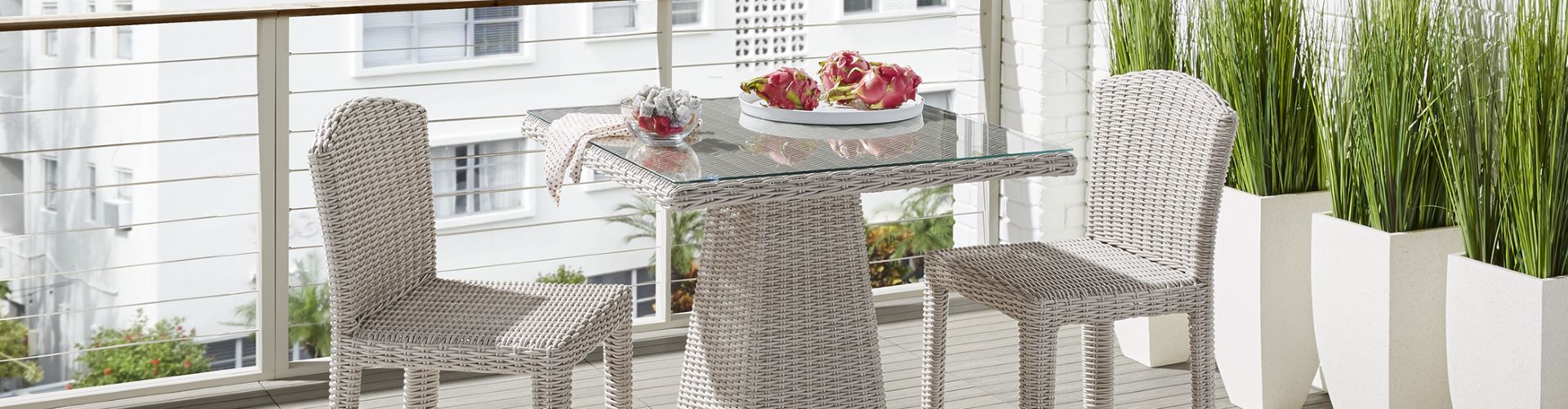 Outdoor patio set with a glass-top table, two chairs, and dragon fruit.