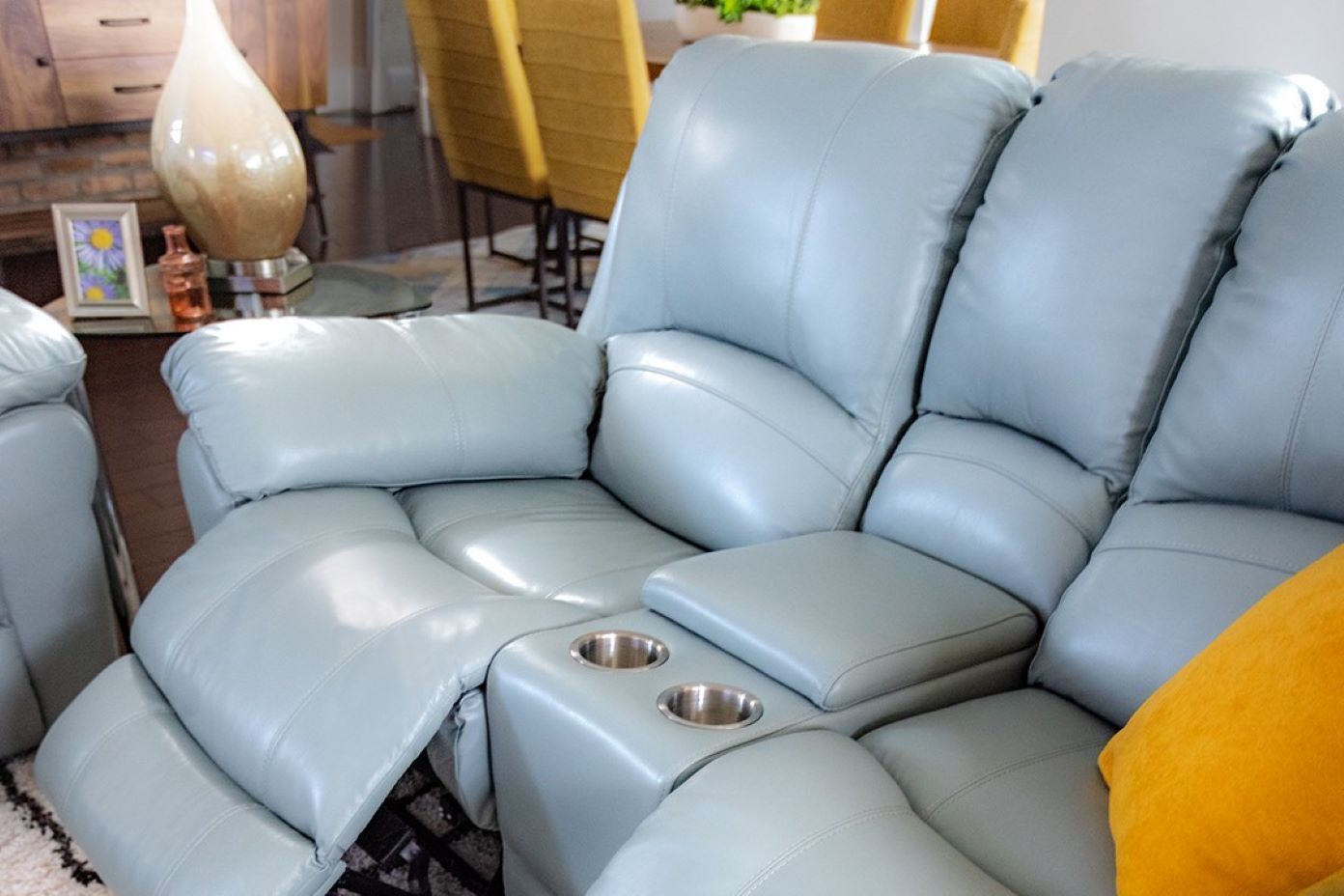 Blue leather reclining sofa with cup holders.
