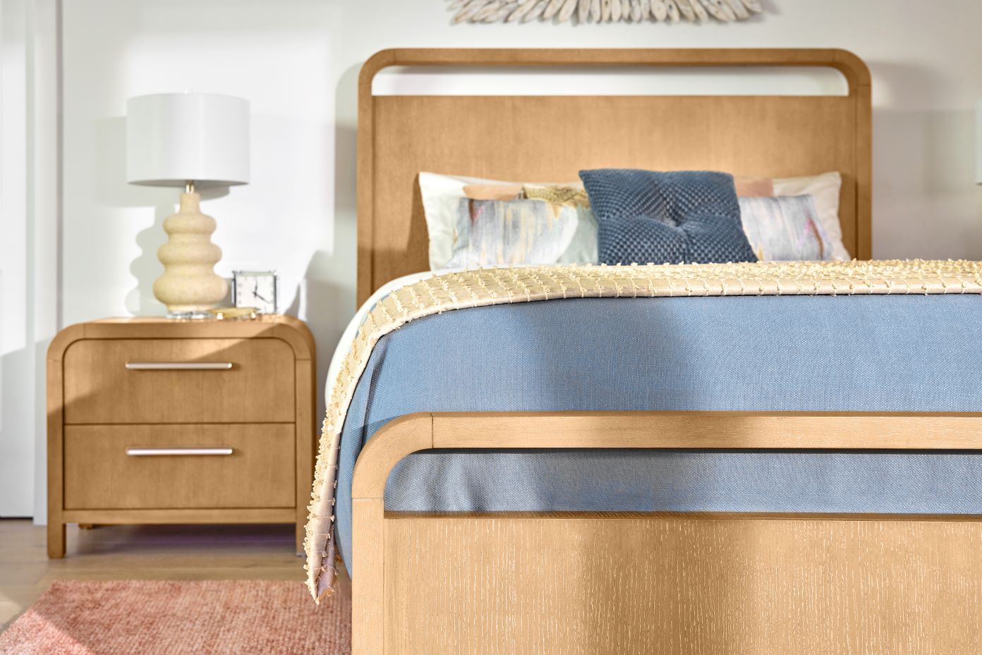 Bedroom furniture with a bed, nightstand, and lamp.
