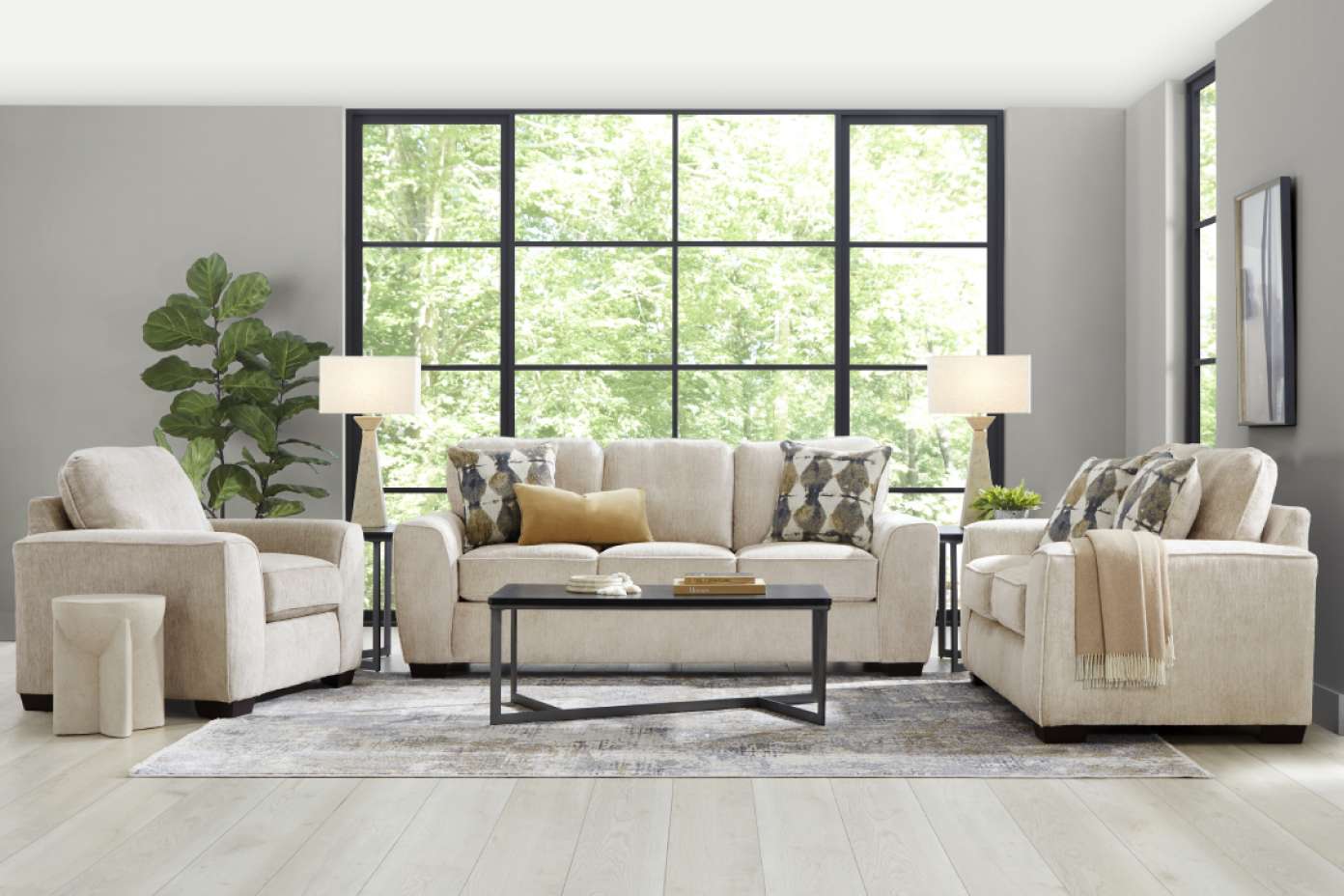 Living room with beige sofa, armchairs, and a black coffee table.
