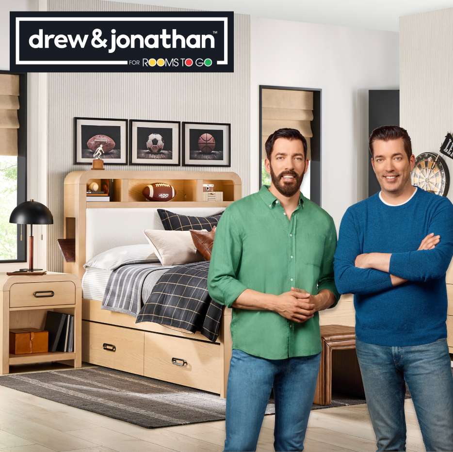 drew & jonathan for Rooms To Go. Two men stand in a bedroom with furniture.
