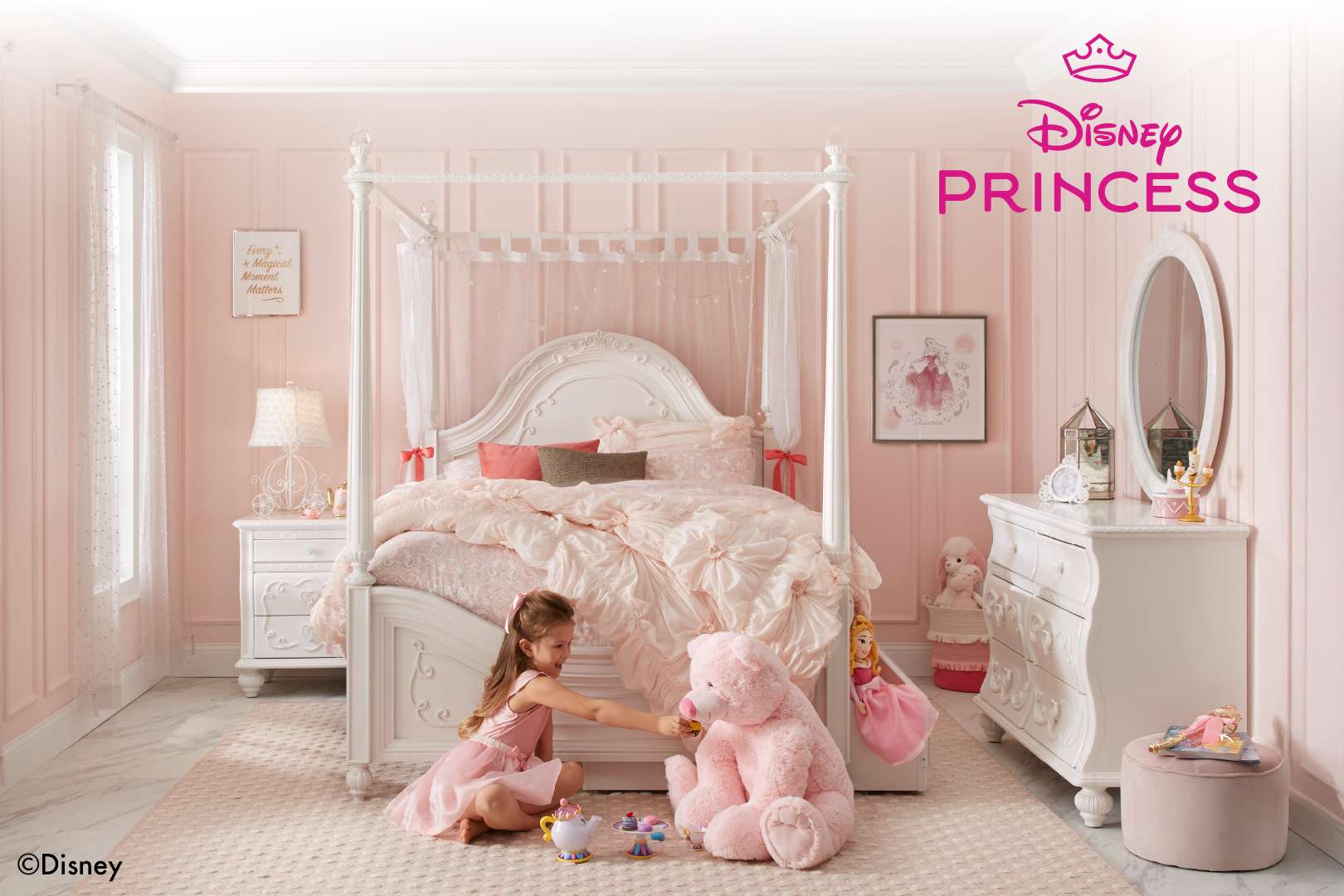 Disney Princess bedroom set with a girl playing with a teddy bear.
