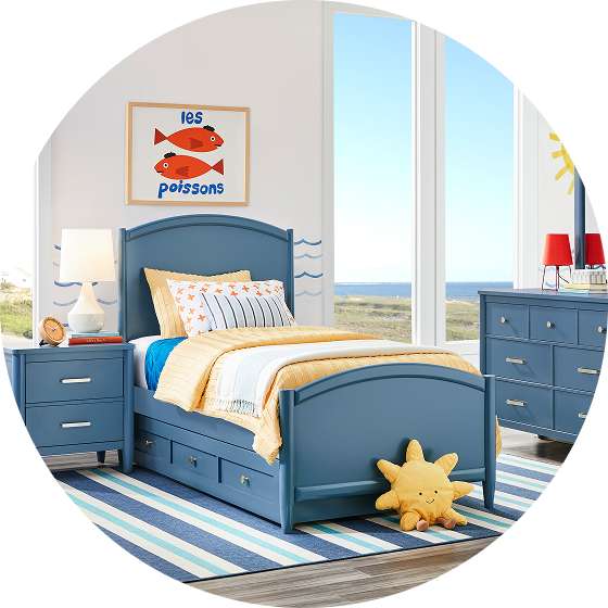 A blue bedroom set with a bed, nightstand, and dresser. A fish art piece hangs on the wall.
