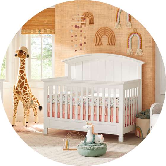 A white crib in a nursery with a giraffe and rainbow decorations.
