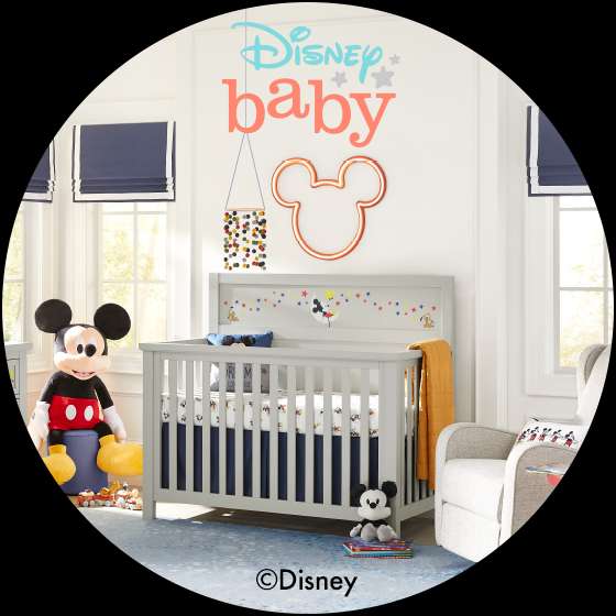 Disney baby nursery with a crib, Mickey Mouse decor, and a rocking chair.
