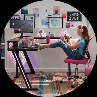 A young person playing a video game at a desk with colorful lights.
