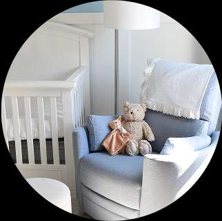 Baby nursery with a crib, rocking chair, and stuffed animals.
