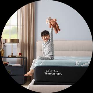 TEMPUR-PEDIC mattress with a child holding a teddy bear.
