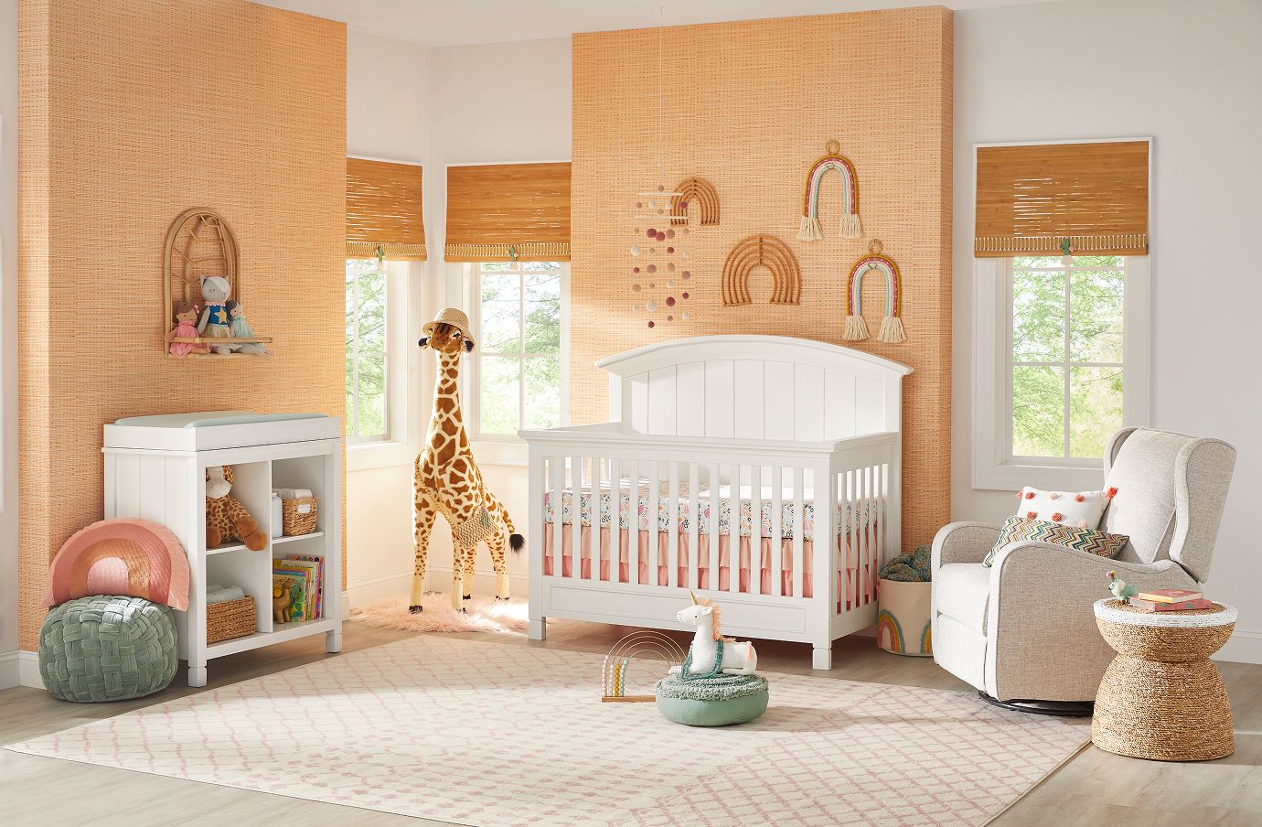 A nursery with a white crib, a giraffe, and a rocking chair.
