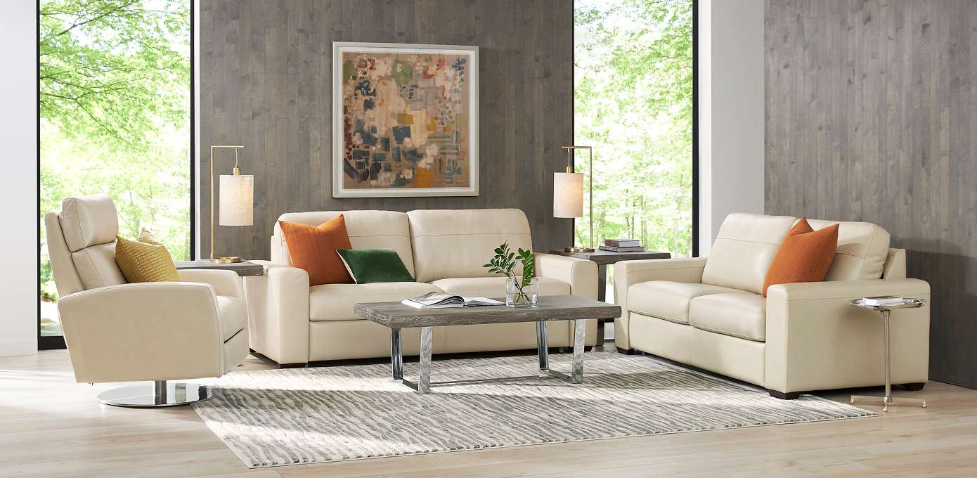 Living room with cream-colored leather furniture, a rug, and a coffee table.
