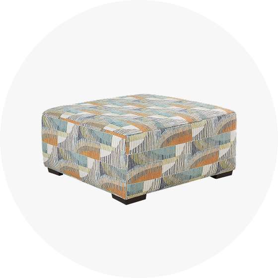 Square patterned ottoman with dark wooden feet.
