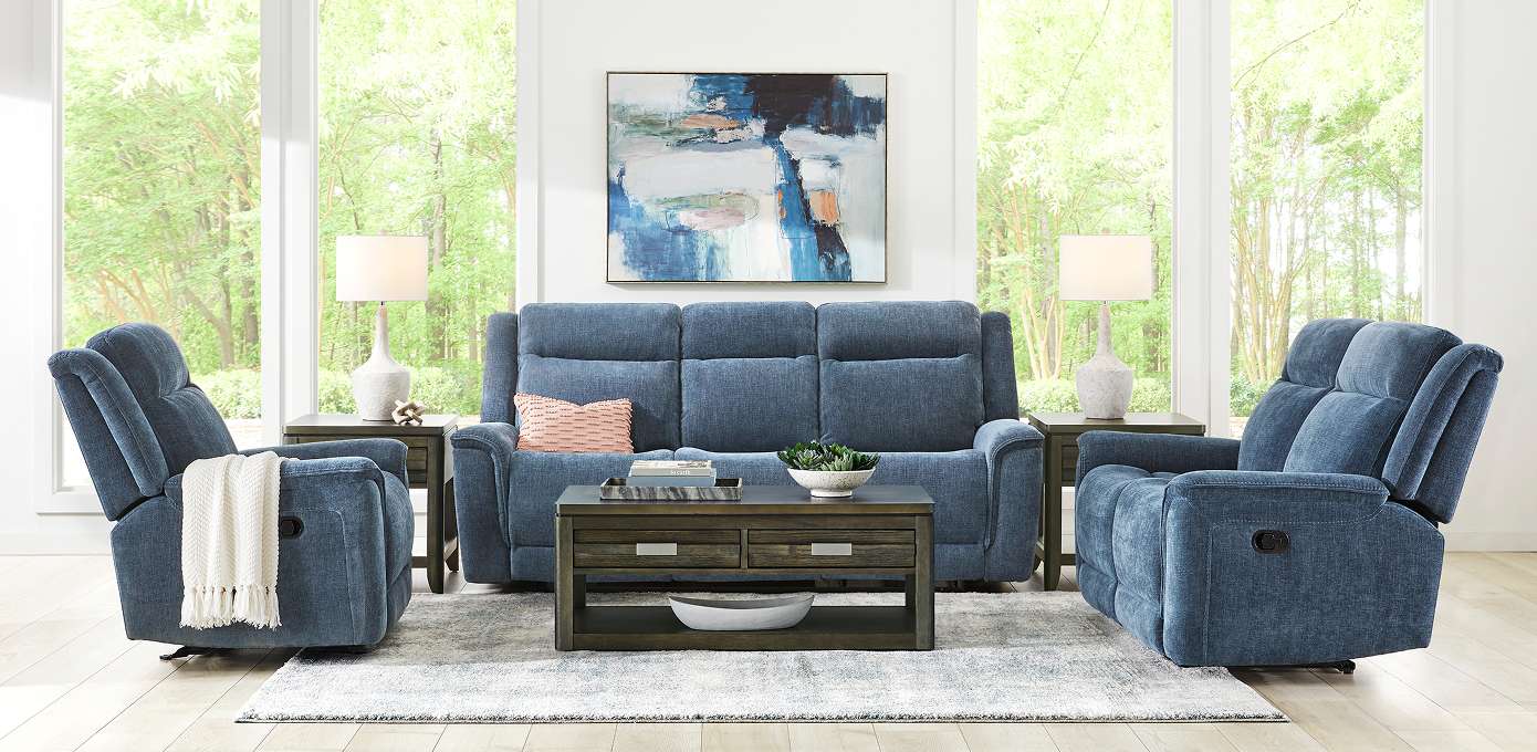 Blue sofa and recliners with a coffee table and artwork.

