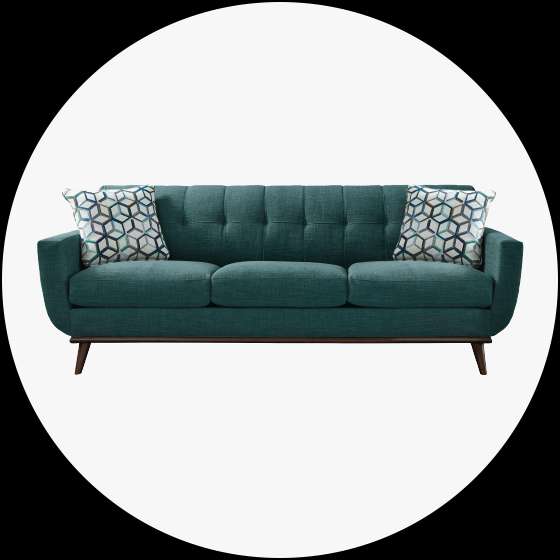 Teal sofa with two patterned pillows.
