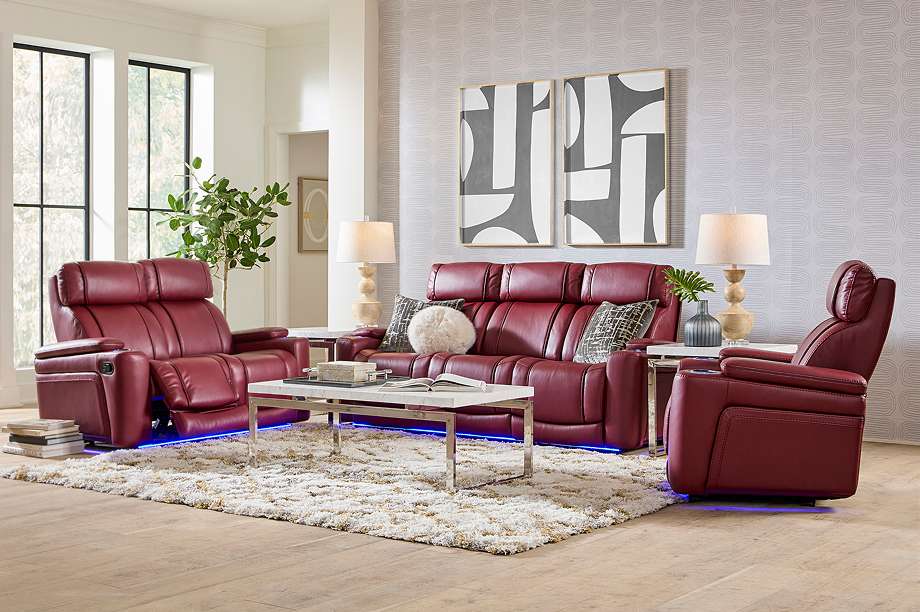 A red leather sofa set with a coffee table and rug.
