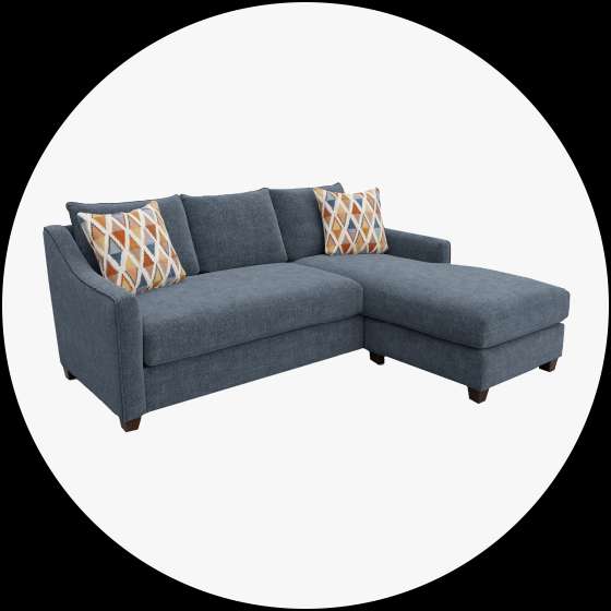 Blue sectional sofa with two patterned throw pillows.
