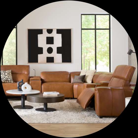 A brown leather sectional sofa in a living room with a rug and coffee tables.
