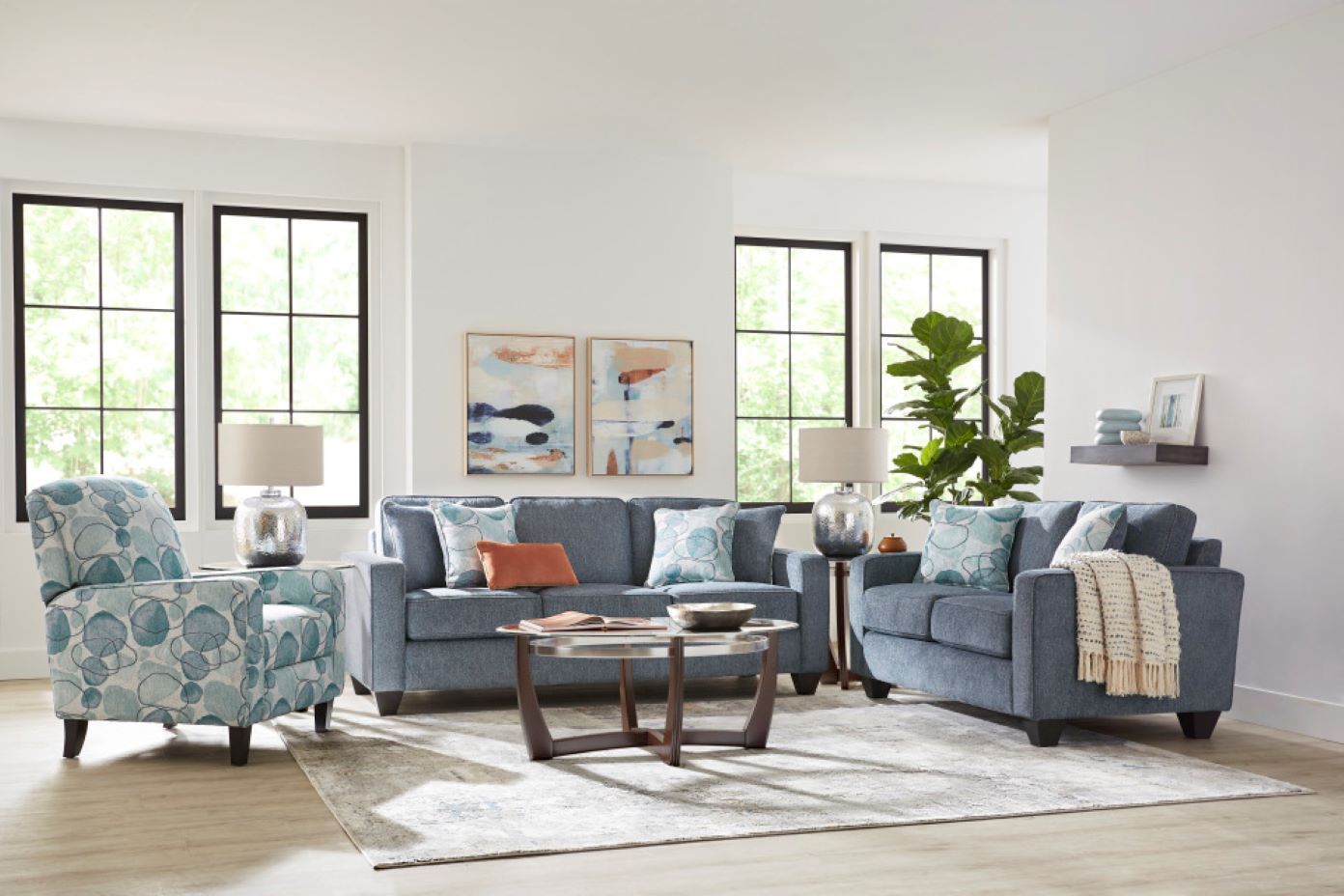 Living room furniture set with blue sofas, patterned armchair, and coffee table.
