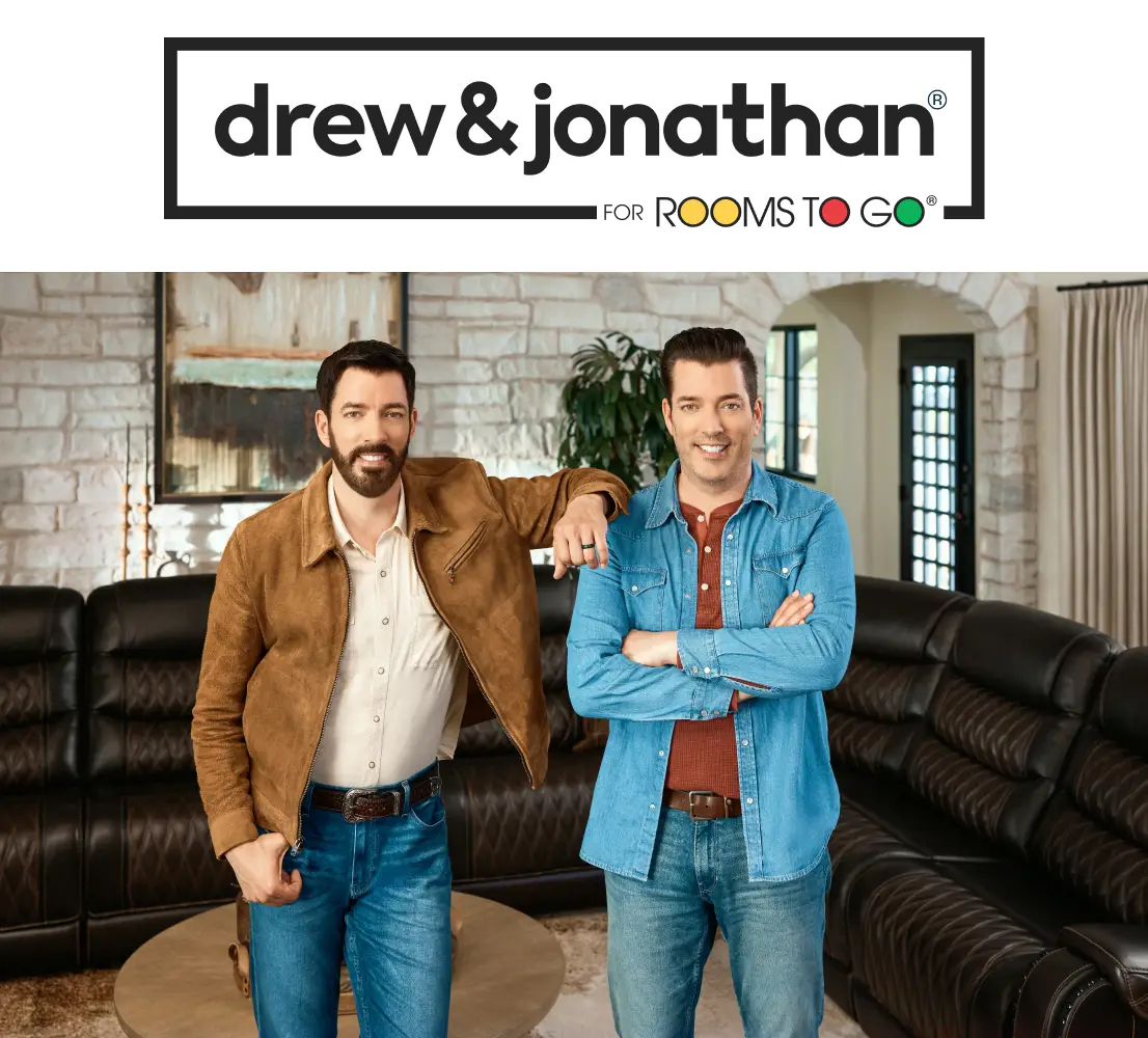 Drew & Jonathan for Rooms To Go: Drew and Jonathan Scott standing in front of a dark brown leather sectional sofa.